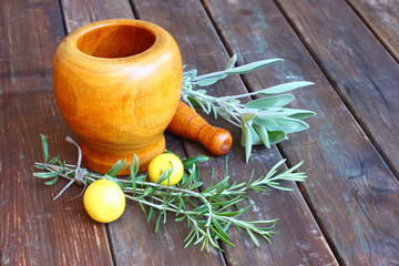 fresh rosemary herbs in wooden pestle and mortar on wooden table