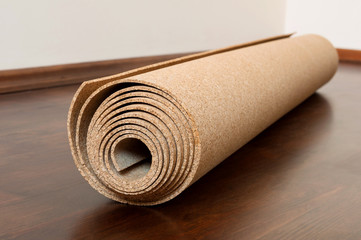 Roll of cork lies on a brown floor