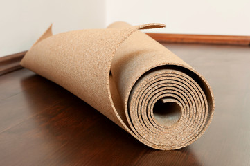 Roll of cork lies on a brown floor