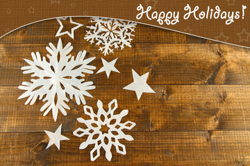 Beautiful paper snowflakes on wooden background