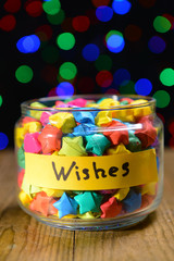 Paper stars with dreams on table on dark background