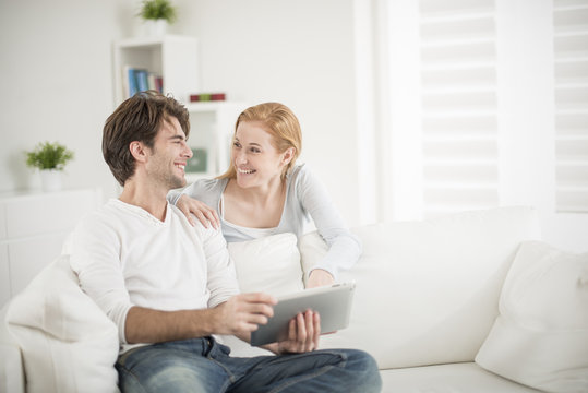 Cheerful Couple Watching A Digital Tablet