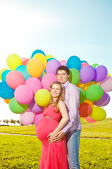 Fototapeta na wymiar Young healthy beauty pregnant woman with her husband and balloon