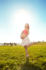 Young healthy beautiful pregnant woman outdoors. A girl with a t