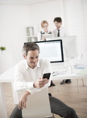 Fototapeta na wymiar portrait of a businessman watching his smartphone at office