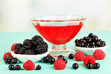 Jelly with fresh berries on green wooden table