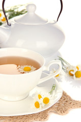 Cup of herbal tea with camomiles close up