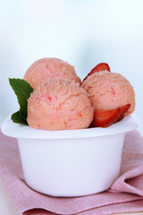 Tasty ice cream scoops in bowl, on table