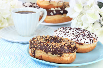 Sweet donuts with cup of tea on table close-up