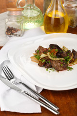 Fried chicken livers on plate on wooden table close-up