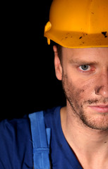 Portrait of young worker on dark background