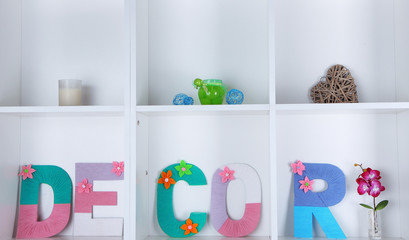 White shelves decorated with handmade knit word