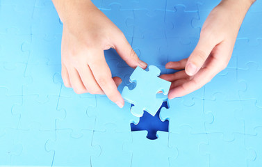 Hand holding puzzle piece, close up