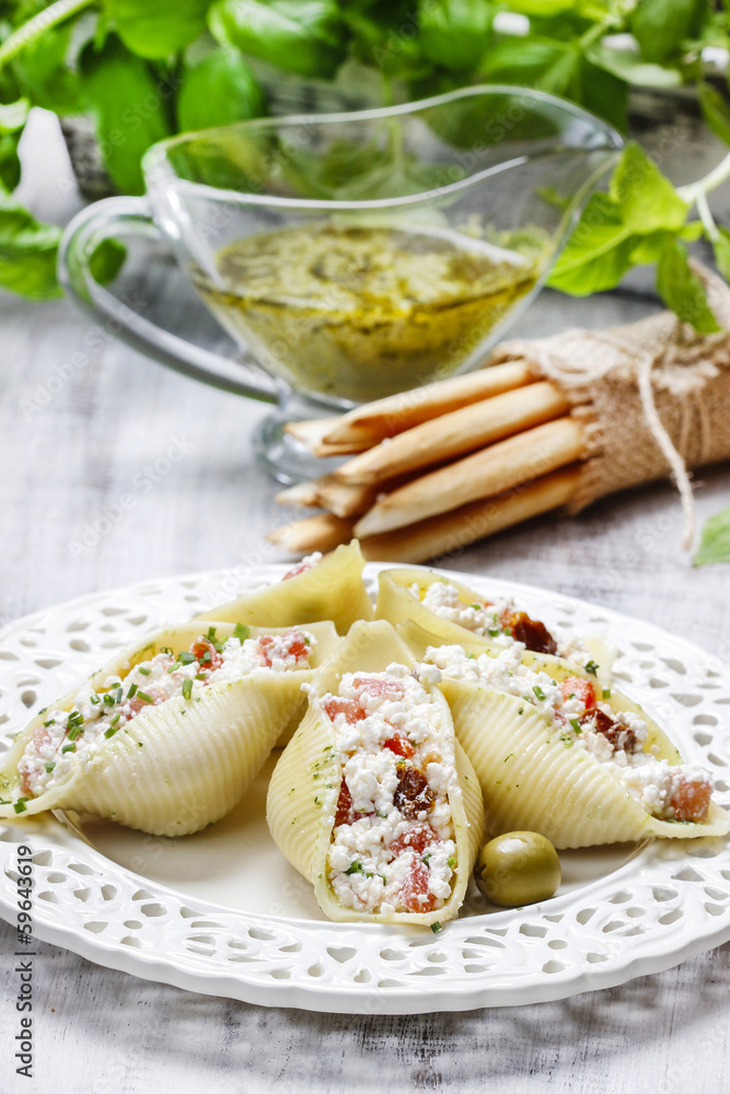 Sticker italian cuisine: stuffed pasta shells and stack of breadsticks.