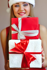 Woman holding out Christmas gifts on the palm of her hand