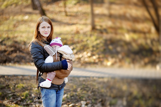 Young mother and her baby in a carrier