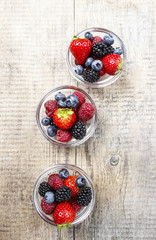 Fruit salad in small transparent bowl on wooden table