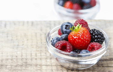 Fruit salad in small transparent bowl on wooden table