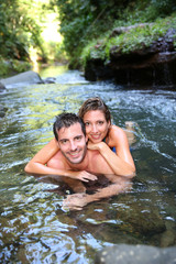 Fototapeta na wymiar Cheerful couple bathing in river waters