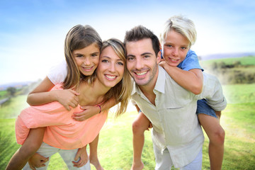 Parents giving piggyback ride to kids