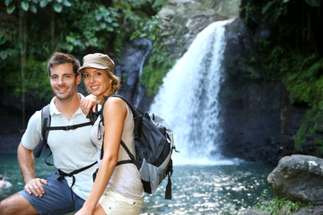 Trekkers reaching waterfall in natural landscape
