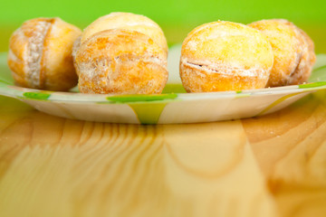 Close-up of the baking round sweets on the plate on the vivid gr