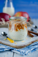 Milk-rice dessert with caramelized apples in glass jar