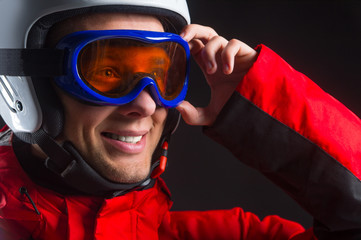 Close up of active smiling guy in ski hamlet and glass mask.