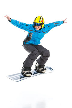 Female skillful snowboarder jumping raising hands up.