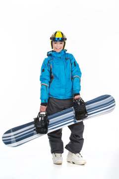 Attractive female snowboarder posing with snowboard.