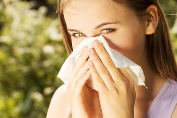 Attractive young woman outdoor with tissue.