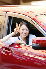 車の前でピースする女性