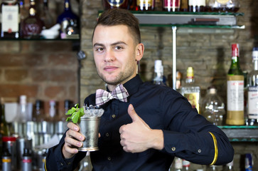 young man working as a bartender in a nightclub bar