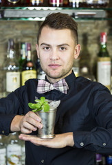 young man working as a bartender in a nightclub bar