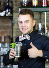 young man working as a bartender in a nightclub bar
