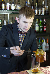 young man working as a bartender in a nightclub bar