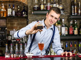 young man working as a bartender in a nightclub bar