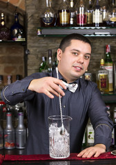 young man working as a bartender in a nightclub bar