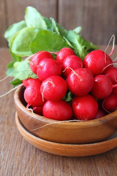 bunch of a red garden radish with green leaves