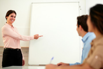 Beautiful caucasian woman pointing at whiteboard