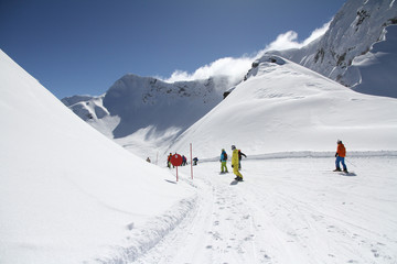 Fototapeta na wymiar Skiers going down the slope at ski resort