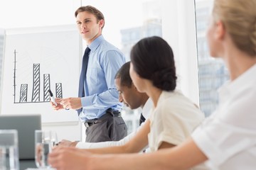 Obraz premium Businessman presenting bar chart to colleagues