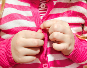 Little girl buttoning her jacket