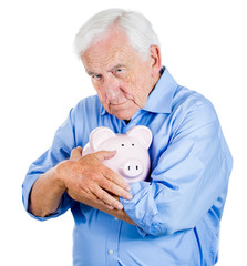 Old, retired man holding piggy bank. Financial decisions