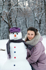 Beautiful brunette near a snowman