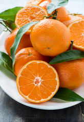 Tangerines with leaves on plate