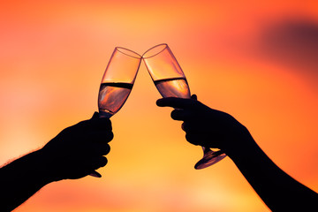Silhouette of couple drinking champagne at sunset