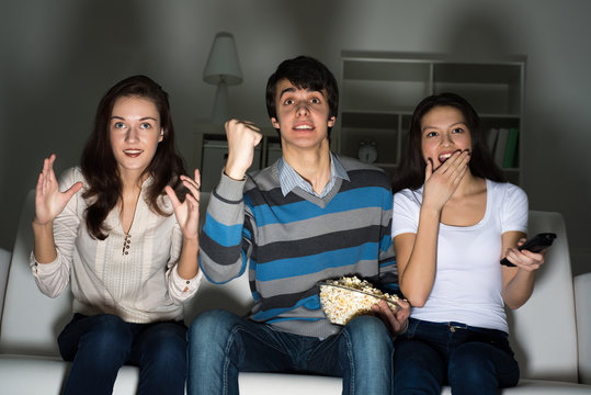 group of young people watching TV on the couch