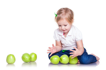 Fototapeta na wymiar Adorable little girl sitting with green apples