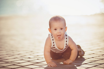 Portrait of a little boy playing outdoors on a dock near the sea